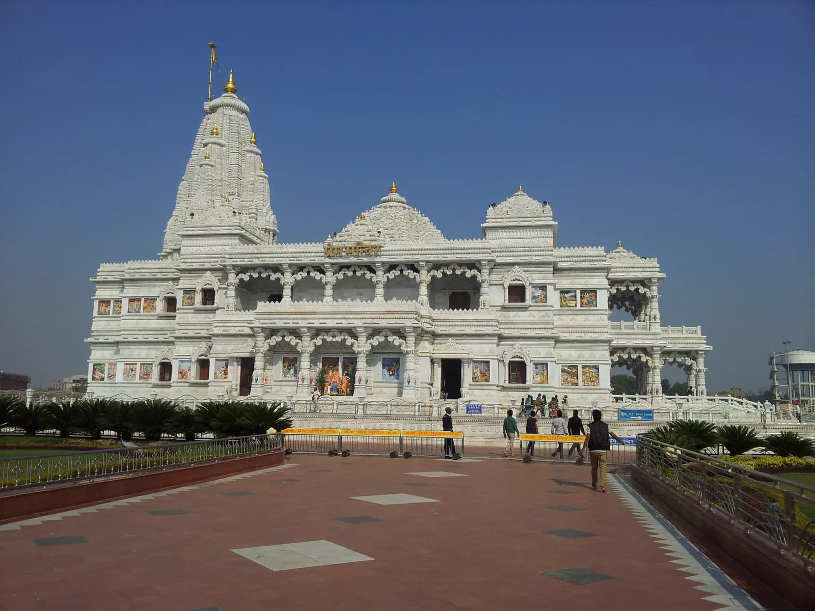 Prem Mandir in Vrindavan on a clear morning, its white marble spire and carved facade rising above the approach walkway